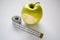 Bitten green apple with measuring tape on white background