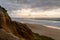 Bizarre eroded sand dunes on the Atlantic Ocean with waves rolling in at sunset