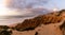 Bizarre eroded sand dunes on the Atlantic Ocean with waves rolling in at sunset