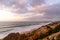 Bizarre eroded sand dunes on the Atlantic Ocean with waves rolling in at sunset