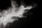 Bizarre forms of of white powder explosion cloud against dark background.