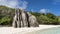 A bizarre granite rock with steep folded slopes on a sandy beach