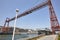 Bizkaia red iron hanging bridge and Nervion river. Euskadi