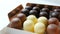 Bizze airy souffle desserts in the form of sweets in the glaze of white, black and milk chocolate. Box of chocolates on