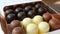 Bizze airy souffle desserts in the form of sweets in the glaze of white, black and milk chocolate. Box of chocolates on