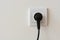 Black 220 volt power plug plugged in a socket