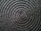 Black abstract woven surface with spiral circles