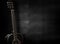 Black acoustic guitar on wooden background.