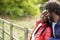 Black adult woman leaning on the shoulder of her boyfriend, standing in the countryside, close up