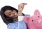 Black African American business woman putting coin into oversized pink piggybank