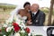 Black african bride kiss by caucasian american groom with wedding car