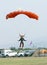 Black African male skydiver coming in for landing on grass with