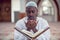 Black African Muslim Man Is Praying In The Mosque with open holy book of Koran