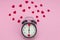 Black alarm clock in retro style with hearts instead of numbers and around in red small hearts. Time for love. Valentine`s Day