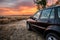 Black all terrain car stopped in nature with the sunset in the s