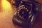 Black antique vintage analog telephone dialing or scrolling phone on wooden table.