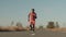 Black athlete stands on the road, looks time on his watch and starts running. African-American is training, down view