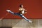 Black athletic man doing an acrobatic jump outdoors