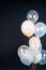 On a black background, balloons of light shades - white, beige, transparent - are flying. Space for text