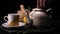 On a black background, a brewed teapot teapot on a tray is a lemon and a grassy saucer, from the kettle a lot of steam comes out