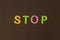 On a black background, bright multicolored stickers with the word STOP. Illustration