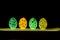 On a black background, Easter eggs glow in neon.
