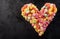 Black background with heart shape made of candies