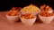 Black background with Namkeen or Assorted Salty Snack on wooden spoon in white bowl close up, indian sneak,Namkeen in a bowl,