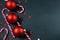 Black background with red christmas balls, candy canes and stars. Overhead flat lay with copy space