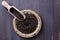 Black barley grains over wooden background