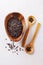 Black barley grains on wooden plate over rustic wooden background