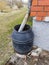 A black barrel for sewage is attached to the house by the gutter