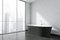 Black bathtub in the white panoramic bathroom interior. Corner view