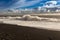 Black beach, big waves, blue dramatic sky with clouds