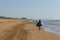 Black beach salesman walking with bags