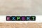 Black bead with letter in word expert on wood background