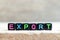 Black bead with letter in word export on wood background