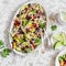 Black bean salad. Salad with corn, beans, avocado and tortilla. On a light background