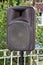 Black big speaker on stand outdoor / A big p.a. speaker on a stage at an outdoor music festival / Large audio speaker.