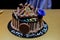Black birthday cake with chocolate sticks. Classic birthday