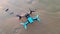 Black and blue drone standing on the sand