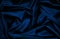 Black blue silk satin. Wavy folds. Shiny fabric surface. Elegant navy blye background