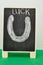 A black board with a horse shoe and the word luck drawn on to it