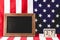 Black board near american flag and wooden cubes with date