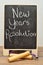 A black board with the words new years resolution and a jumping rope