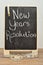 A black board with the words new years resolution and a measuring tape