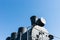 Black boiler of a steam locomotive against the background of clear blue sky. You can see an electrical headlight, chimney or