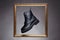 Black boots in golden Frame. fashion shoes still life