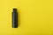 Black bottle vial on yellow background. Copy space. Mock up