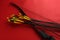 Black bow and set of arrows on red background. Archery sports equipment